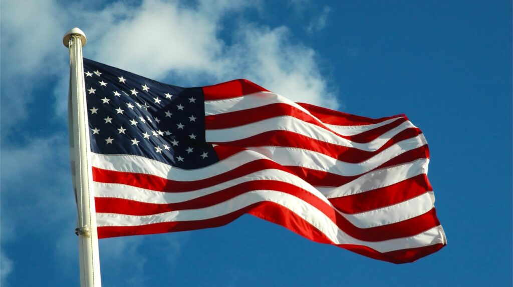 American flag flying with a blue sky background