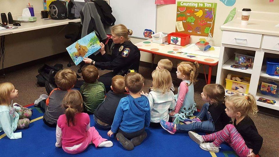 Photo of Pittsburg Police Officer reading to children in a classroom
