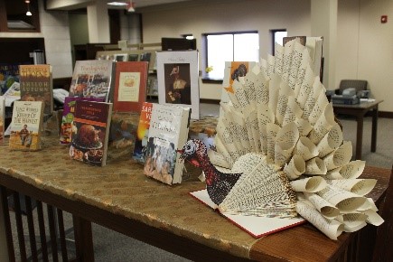 Photo of library books on display, including a turkey made from recycled library book pages.