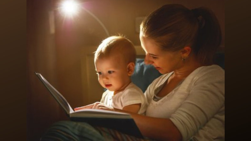 Painting of a mom reading to a baby on her lap