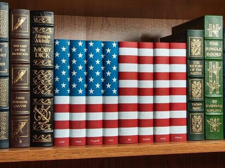 Books on a shelf. The spines of the middle books come together to make an American flag.
