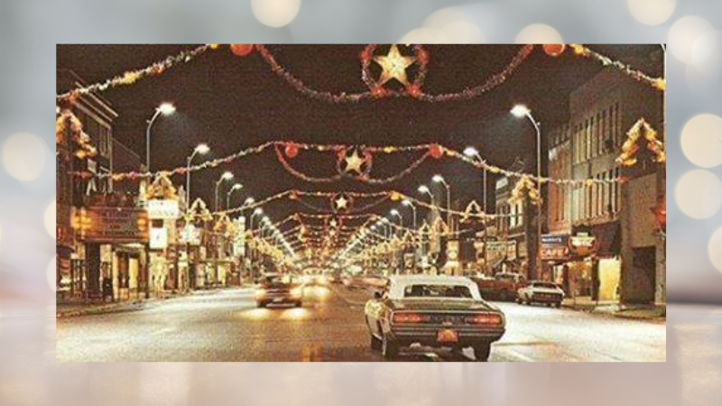 Vintage photo of Downtown Pittsburg, Kansas with old fashioned holiday lights hanging over the street.
