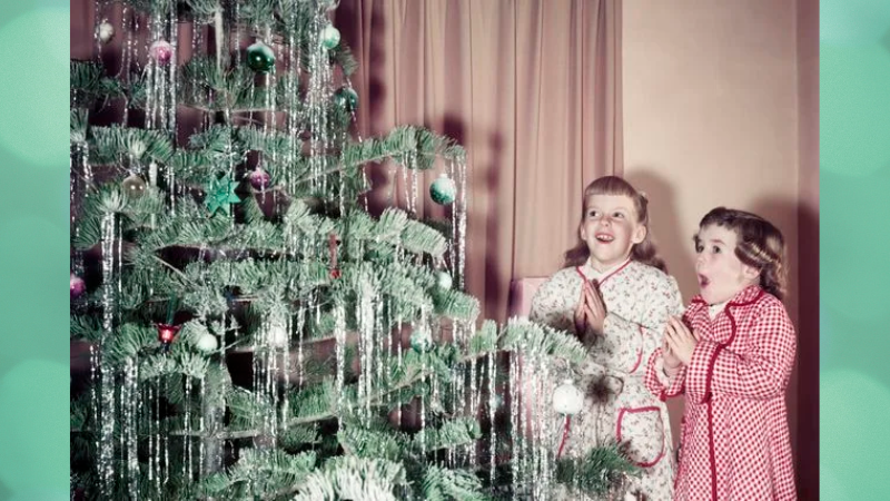 A vintage photo of two young girls gazing up at their beautiful xmas tree