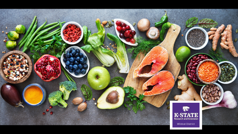 A table of healthy fresh food including fruits, vegetables, and lean meat and fish. Logo for: K-State Research & Extension Wildcat District