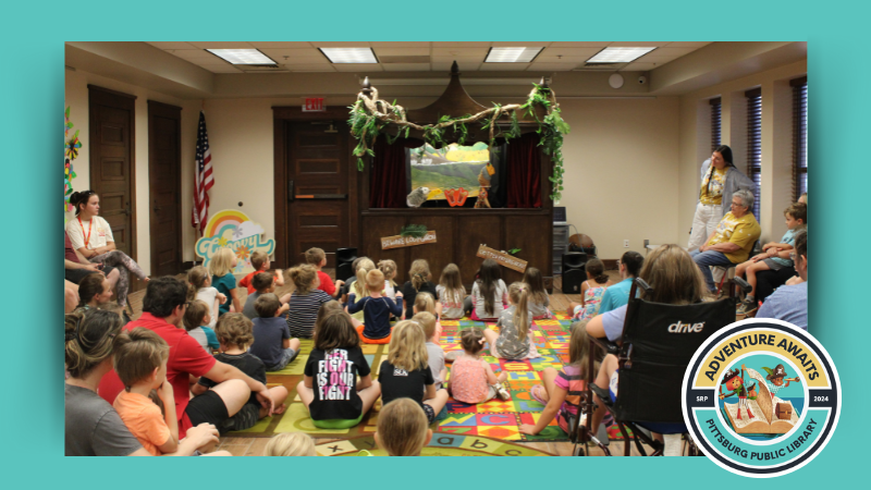 A photo of the Library's puppet stage with an audience of kids. The Logo "Adventure Begins" is in the bottom right corner.