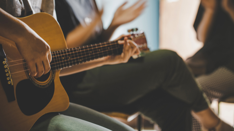 a person playing an acoustic guitar